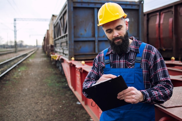 Worker dispatching cargo containers for shipping companies via freight train and organizing goods to be exported