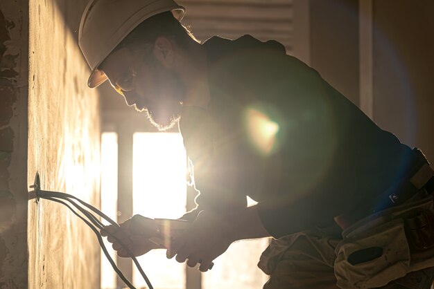 Worker is cutting wires with lineman's pliers.