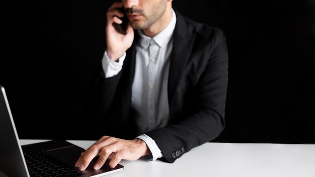 Worker in office using notebook and smartphone