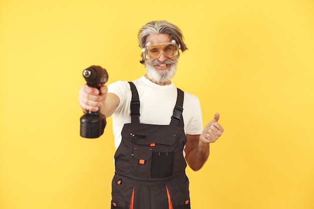 Free photo worker in overalls. man with tools. senior with screwdriver.