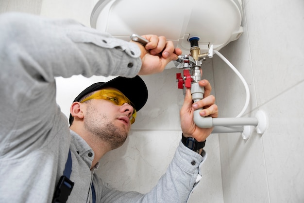 Free photo worker repairing water heater