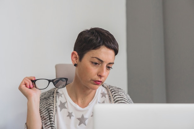 Worker thinking while looking at laptop screen