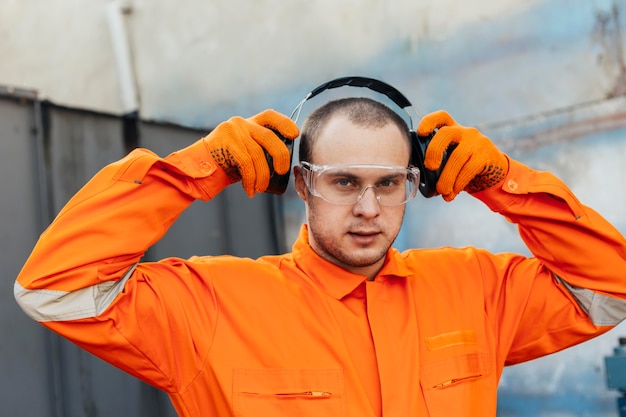 Free photo worker in uniform with headphones and protective glasses