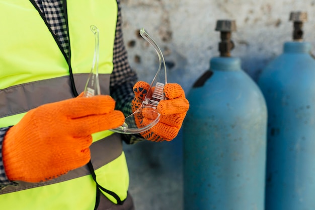 Worker with gloves holding protective glasses