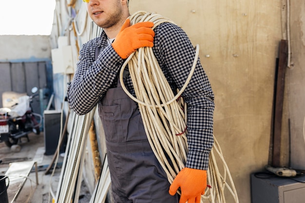 Free photo worker with hard hat carrying rope