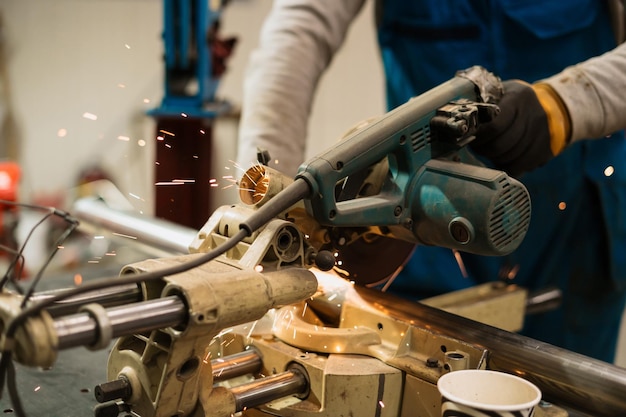 Worker working with a circular grinder on a metal with sparks