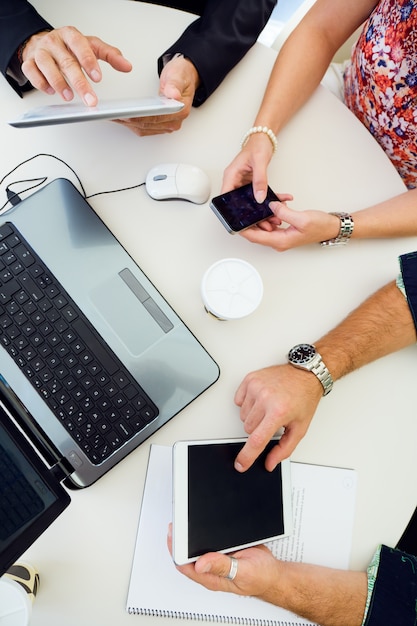 Free photo workers using devices at workplace