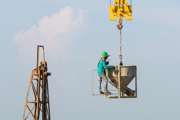 Free photo workers work on the crane in construction site