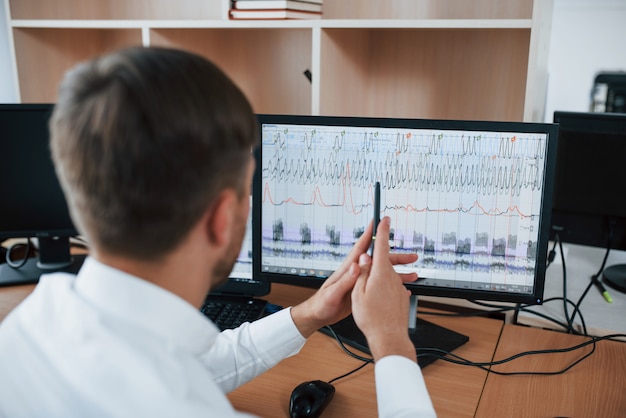 Free Photo working process. polygraph examiner in the office with his lie detector's equipment