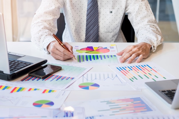 Free photo working process startup. businessman working at the wood table with new finance project. modern notebook on table. pen holding hand