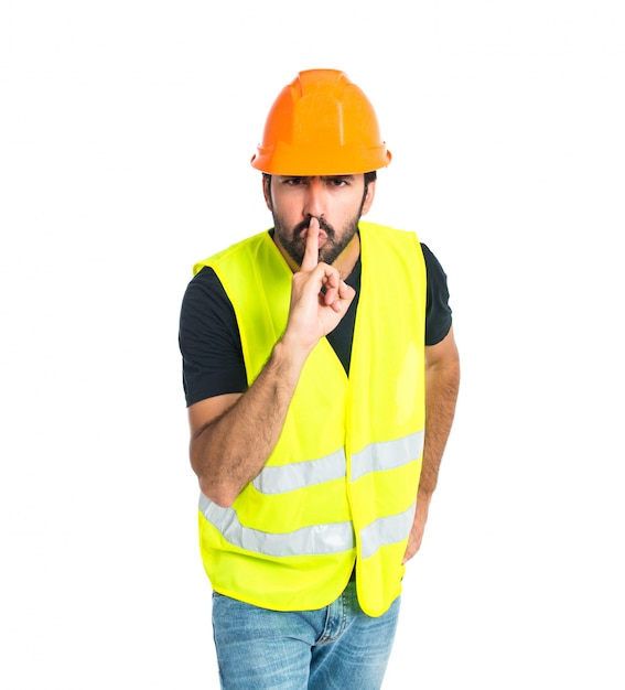 Workman making silence gesture over isolated white background