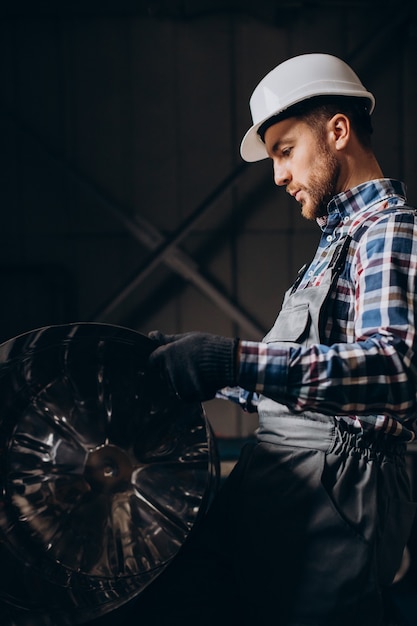 Free photo workman wearing hard hat working with metal constructions at factory