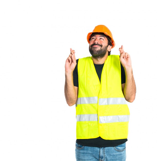 Workman with his fingers crossing over white background