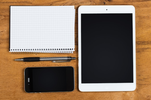 Workplace. Phone, tablet and notepad on the table