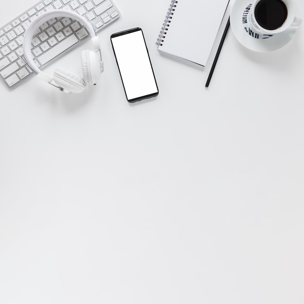 Free Photo workplace with electronic devices stationery and coffee cup on white table