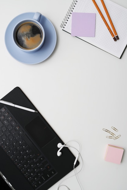 Workplace with laptop, coffee and notepad, top view, copyspace