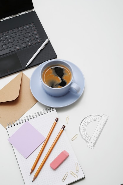 Workplace with laptop, coffee and notepad, top view, copyspace