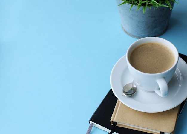 Free Photo workplace with plant, notebooks and coffee cup