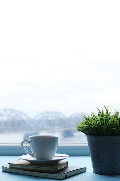 Free photo workplace with plant, notebooks and coffee cup