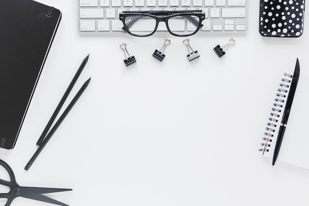 Workplace with stationery and glasses on keyboard 