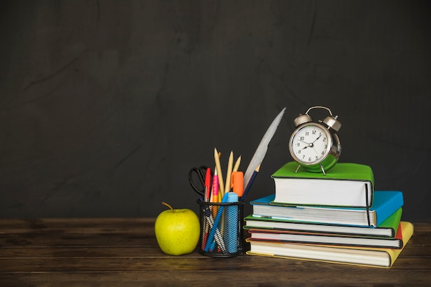 Workplace with textbooks and alarm clock