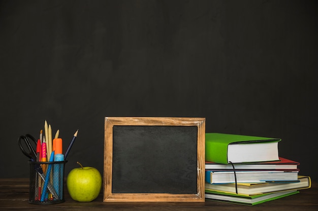 Workspace with books blackboard and stationery