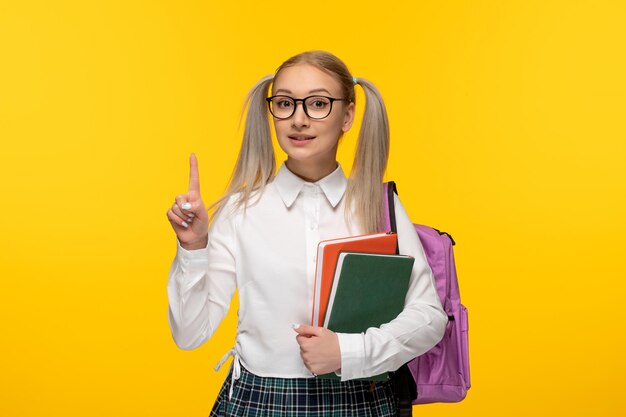 World book day smiling blonde girl holding green and red books