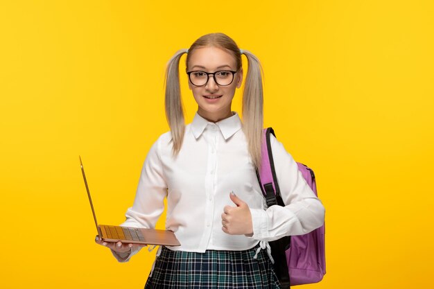 World book day smiling student with ponytails holding a computer