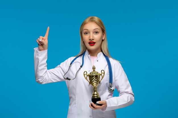 Free photo world doctors day cute young doctor with golden trophy and the stethoscope in the lab coat