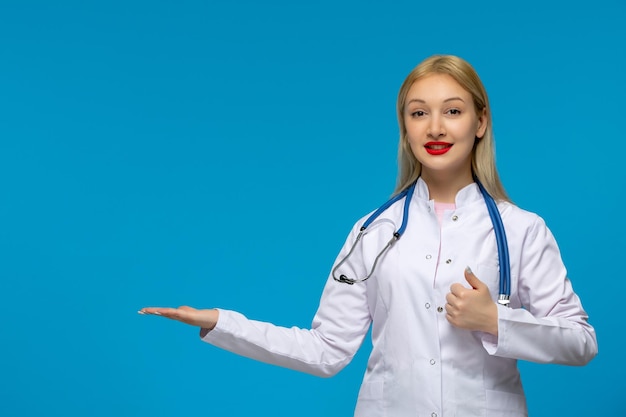 World doctors day happy cute doctor with the stethoscope in the medical gown pointing to the left