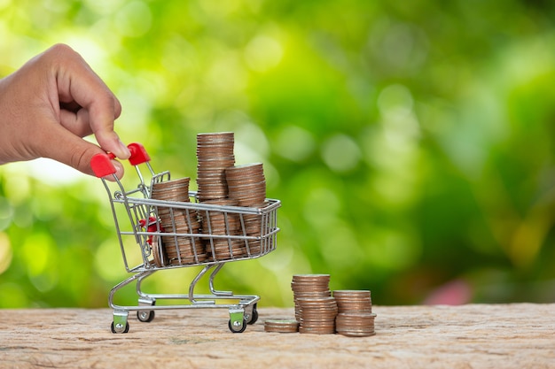 World Habitat Day,close up picture of  a hand pushing little cart which full of coins