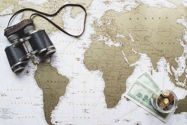 Free Photo world map background with money and binoculars