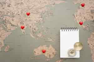 Free photo world map background with notebook and compass