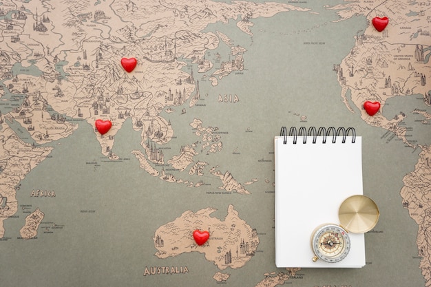 Free Photo world map background with notebook and compass