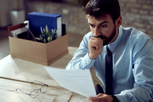 Free photo worried businessman going through paperwork after losing his job in the office