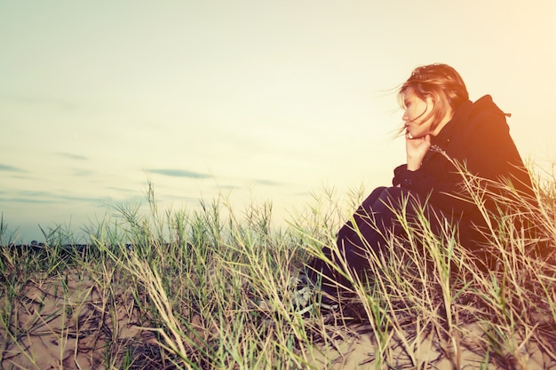 Free Photo worried girl sitting on the sand