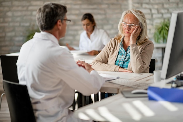 Free Photo worried mature woman talking with healthcare worker about medical insurance during counselling at clinic