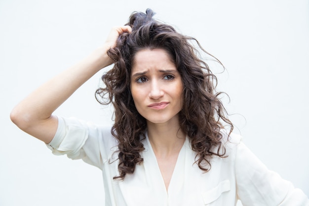 Worried pensive woman scratching head