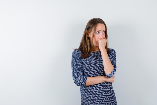 the worried woman is putting her fist on mouth on white background