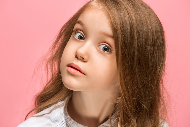 Wow. Beautiful female front portrait isolated on pink. Young emotional surprised teen girl