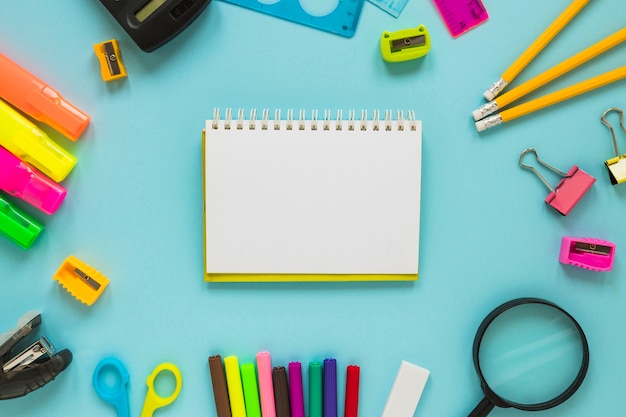 Writing implements laid in circle with jotter in middle