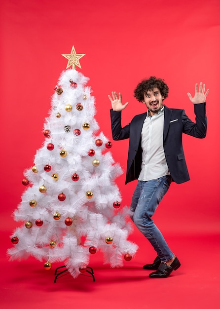 xmas celebration with happy funny young man dancing and standing near Christmas tree