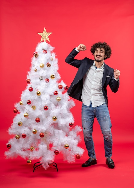 xmas celebration with young happy excited funny man dancing near Christmas tree