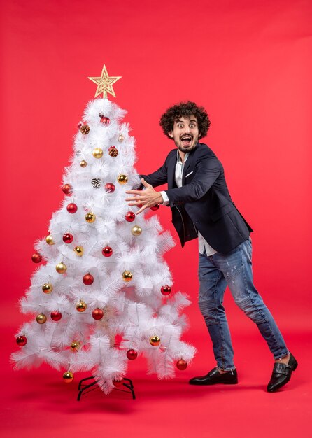 xmas celebration with young happy excited funny man embracing Christmas tree