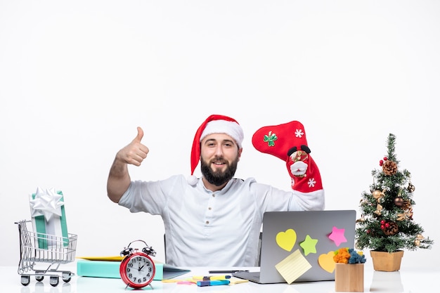 xmas mood with positive young adult with santa claus hat and wear christmas sock to his hand in the office making ok gesture