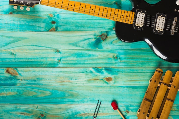 Free Photo xylophone and classic electric guitar on turquoise wooden table