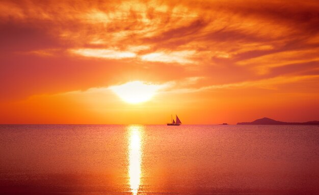 Yacht sailing against sunset. Holiday lifestyle landscape with skyline. Vintage process.