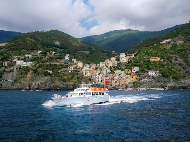 Free photo yacht sailing near the coastal village in riomaggiore, italy