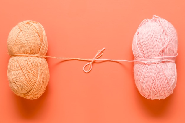 Free photo yarn for knitting tied in bow on orange background