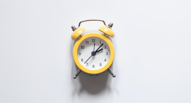 Yellow alarm clock on a white background isolated flat lay